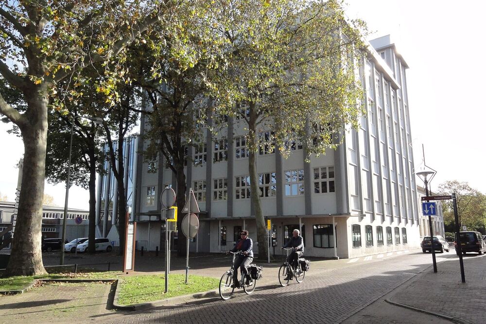 Fietsers passeren het voormalige Turmac-fabriekskantoor dat nu dienstdoet als gemeentehuis van Zevenaar