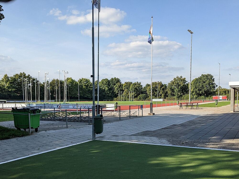 Atletiekbaan met groen veld en vlaggenmasten aan de Heerenmäten in Zevenaar